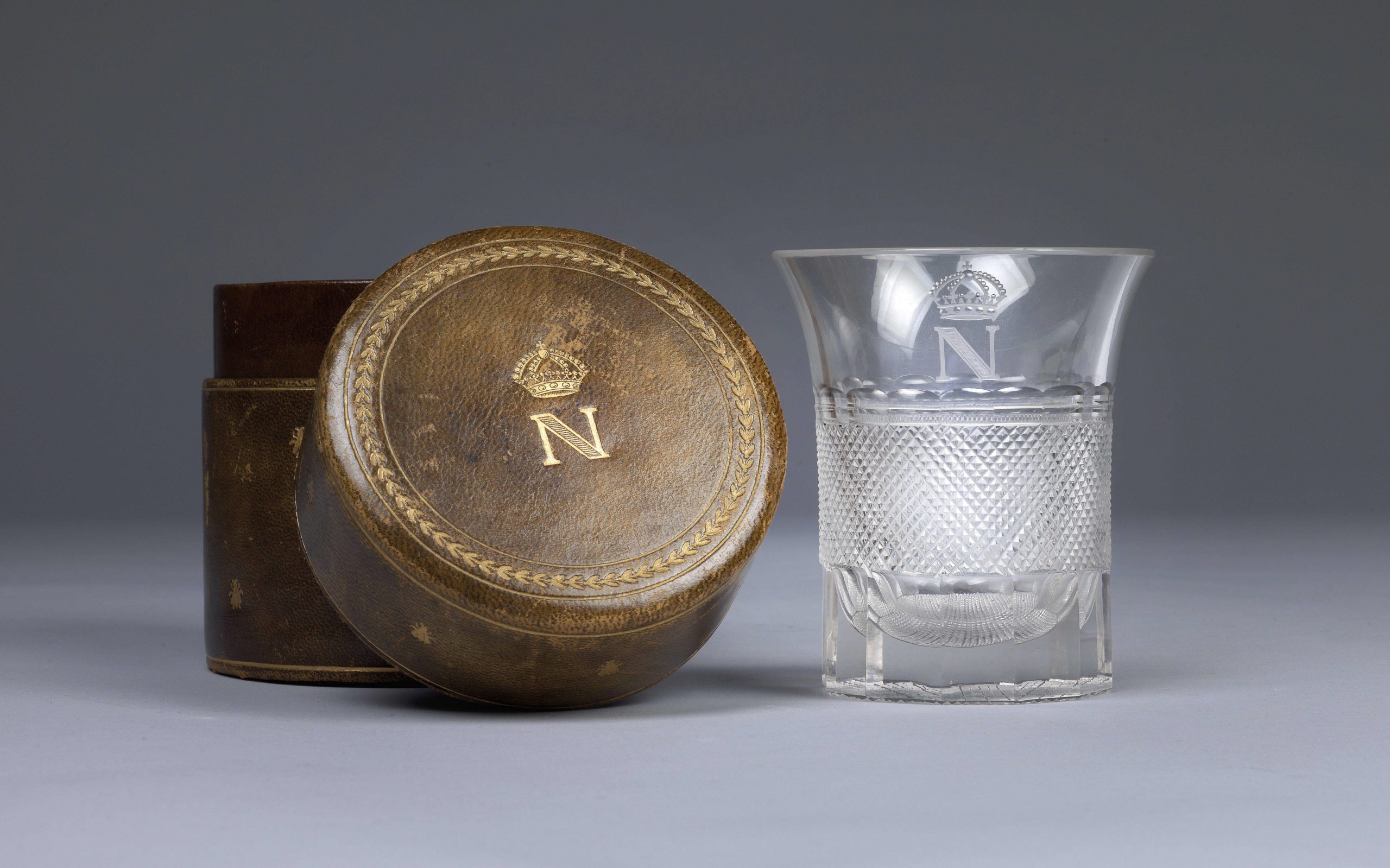 Glass with cut decoration and gilded monogram with crowned N, which belonged to the Emperor Napoleon I. Monogrammed leather case © Dorotheum