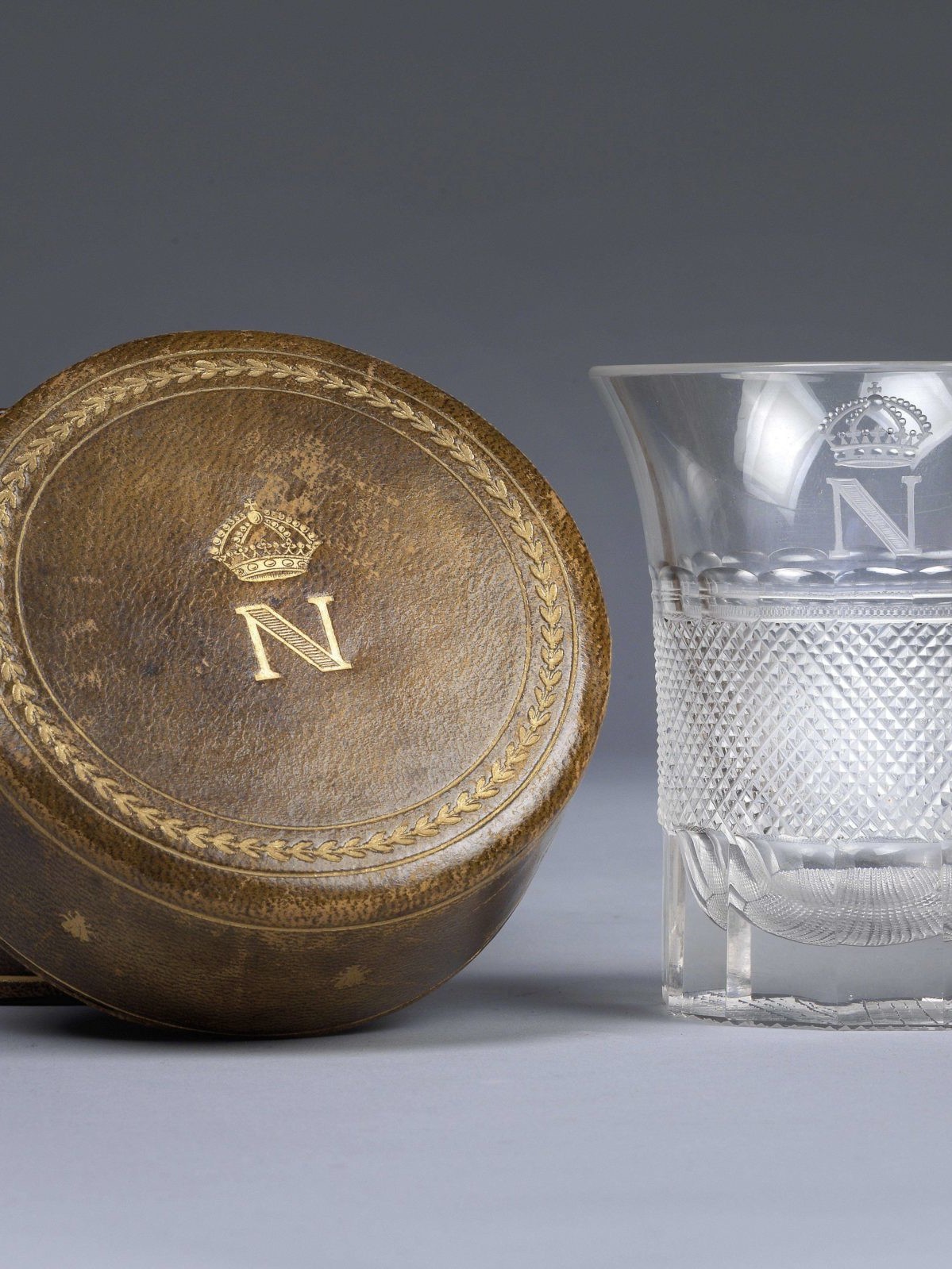 Glass with cut decoration and gilded monogram with crowned N, which belonged to the Emperor Napoleon I. Monogrammed leather case © Dorotheum